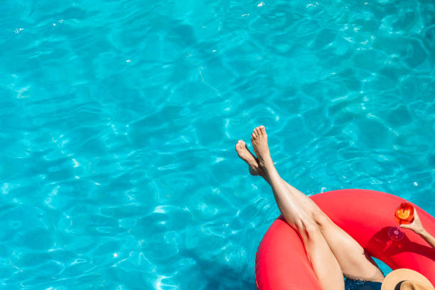 istock Woman relaxing on pink float in swimming pool with drink 2161505719