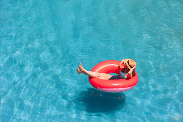 istock Woman relaxing on pink float in swimming pool with drink 2161505723