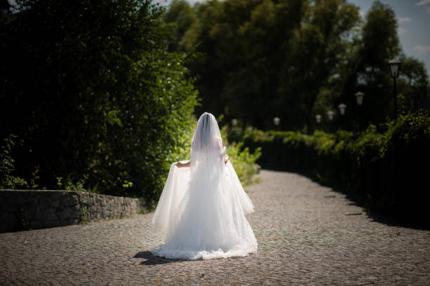 Teenage girl in white dress standing at the top of the hill - holding up scarf
