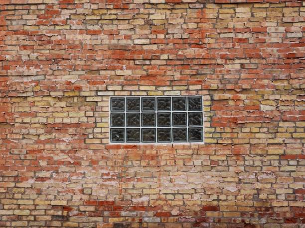 Windows isolated with iron grating and brick ruined wall (Pesaro, Italy)
