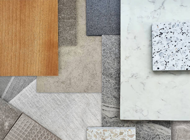 istock group of interior construction material samples including marble stone, wooden veneer, fabric swatch, cement and graphic tiles, terrazo, vinyl flooring tile in close up view. 2161507330