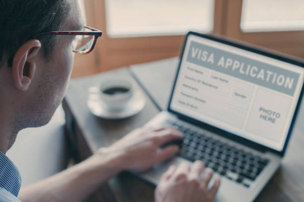 istock Online visa application, man filling form for immigration or tourism visa 2161509089