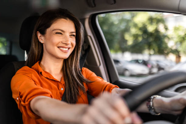 istock Smiling woman is driving a car on her way to work 2161509495