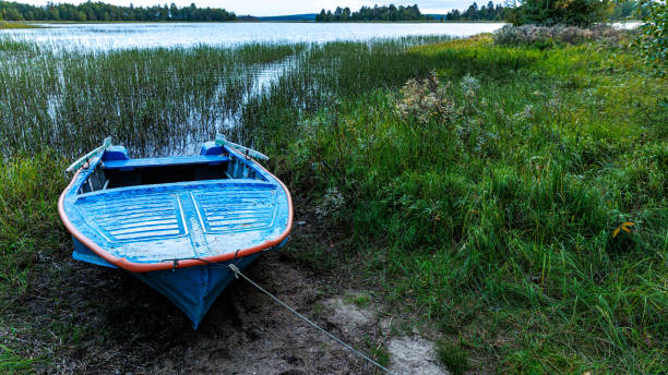 istock A blue boat is securely fastened to the lakes shore 2161512153