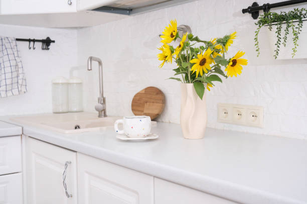 istock Summer cozy break. Cup of tea, ceramic vase with sunflowers on kitchen table. 2161514408