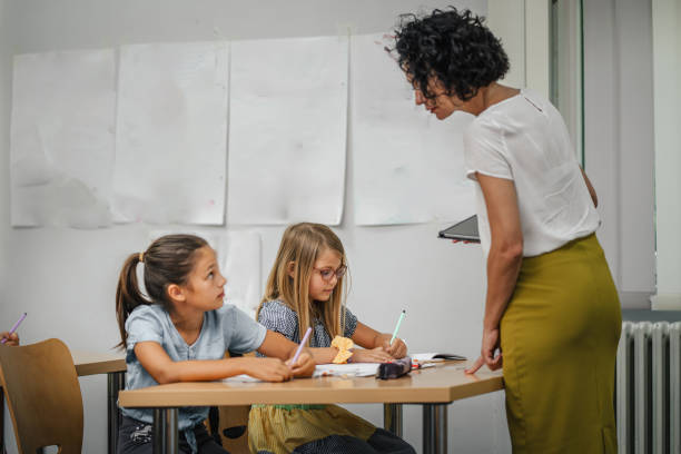 istock Mature teacher hold tablet and check how her students learn lesson 2161515236