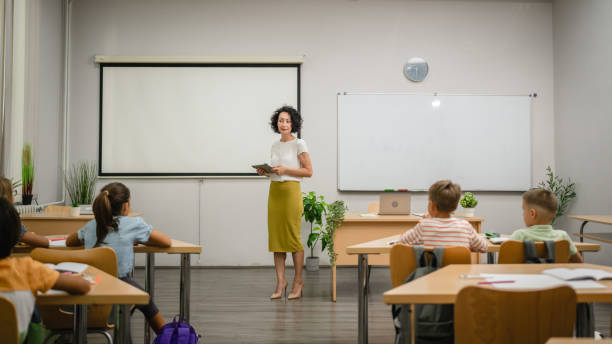 istock Mature teacher teach a lesson young students and hold tablet 2161517341