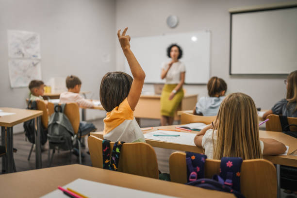 istock Young boy student raise his hand to answer a question during a lesson 2161517377