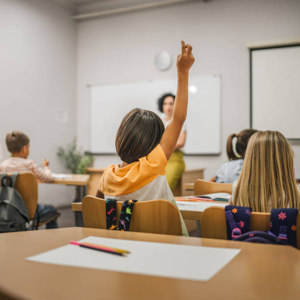 istock Young boy student raise his hand to answer a question during a lesson 2161517384