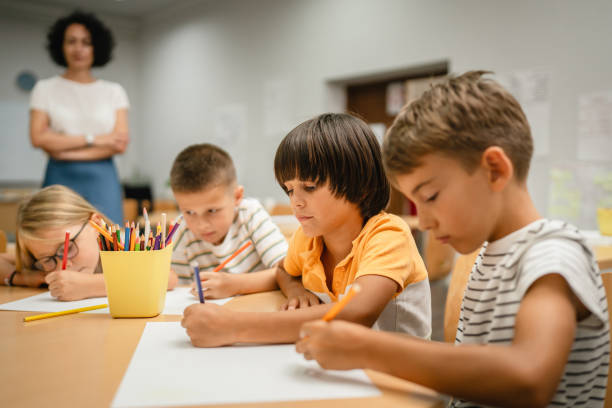 istock Young students paint and draw on class in the classroom with teacher 2161517471