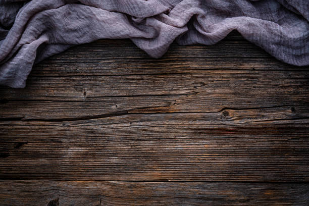 Rustic wood table background with crumpled rag on top. Copy space