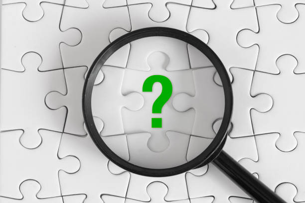istock White Puzzle with Black Magnifying Glass and Green Question Mark, Top View 2161519285