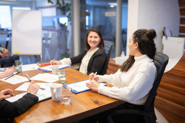 istock Smiling Employees Looking at Each Other in Office Environment 2161519426