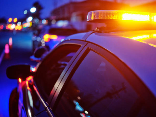 istock Police Car Stopped on a Road at Night with Emergency Lights 2161523865