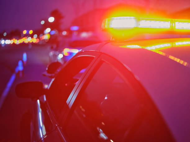 istock Police Car Stopped on a Road at Night with Emergency Lights 2161523907