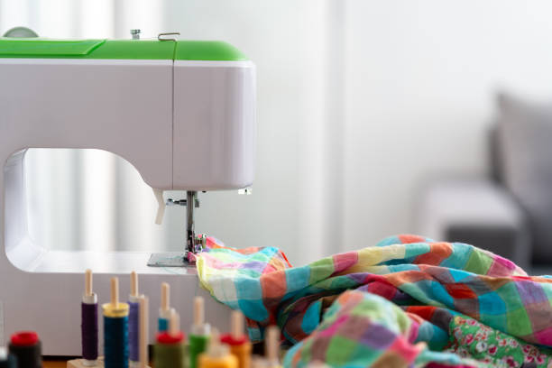 A sewing machine with colorful fabric being stitched, surrounded by vibrant spools of thread. Concepts of creativity and craftsmanship