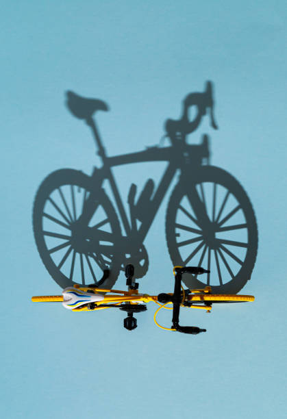 Silhouette of an old bicycle on a dark colored background next to a tree, sunset, blurred abstract backdrop