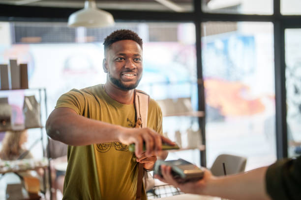istock Young student mobile paying  in a coffee shop. 2161536236