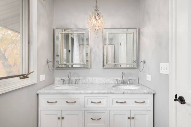 istock A white bathroom with a chandelier hanging over the cabinet. 2161538431