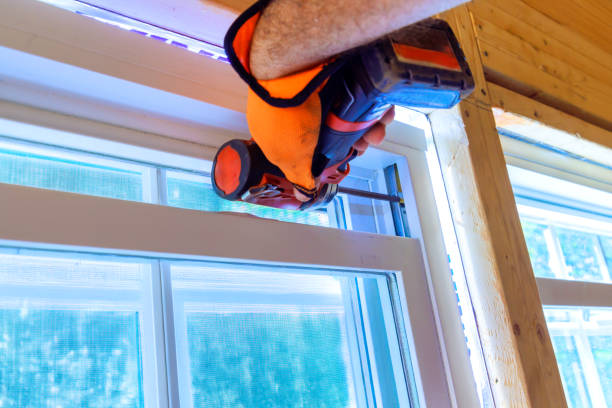 istock Construction worker installs window in new house is uses a screwdriver 2161539730