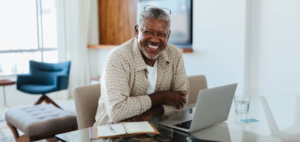 istock Modern Senior: Joyful businessman working from home using a laptop and notebook 2161540199