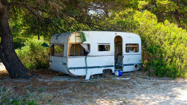 istock Abandoned and damaged caravan in the shade on a beach 2161541148