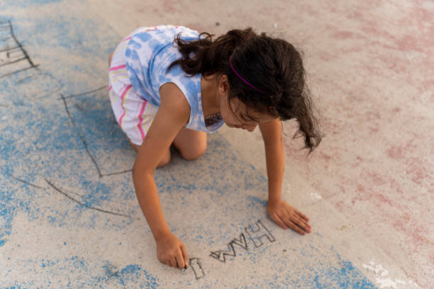 Little girl drawing on the ground.