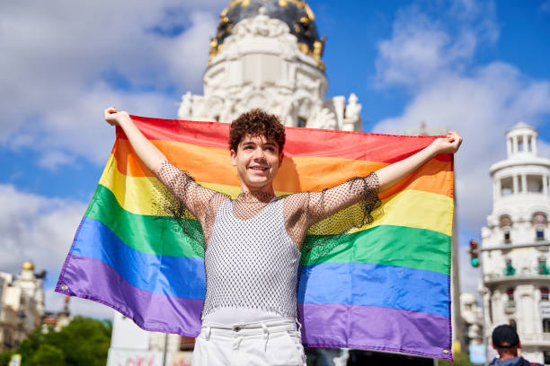 istock A man holding a rainbow flag in front of a building 2161542661