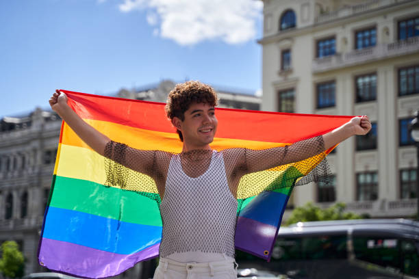 istock A man holding a rainbow flag in front of a building 2161542676