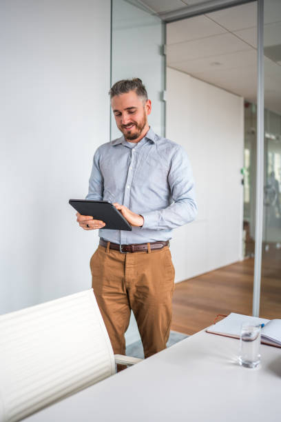 istock Smiling Caucasian Male Employee Walking With Digital Tablet 2161546844
