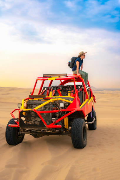 istock Man Standing on Dune Buggy in Huacachina Desert 2161547624