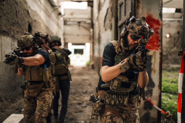 istock Few extreme friends playing air soft war simulation game in ruins. 2161555896