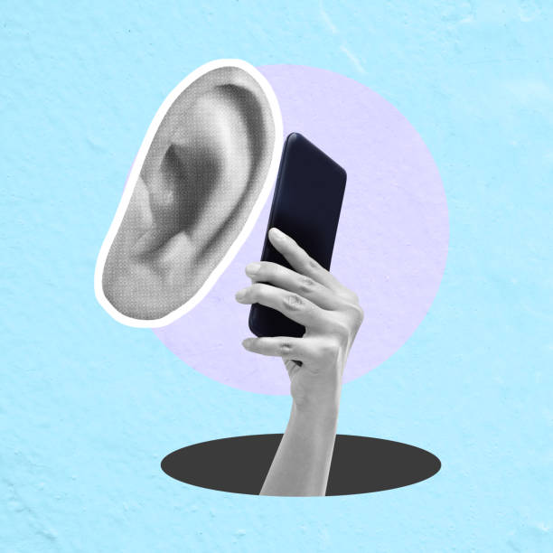 istock Hands holding a smartphone with an ear beside it 2161556751