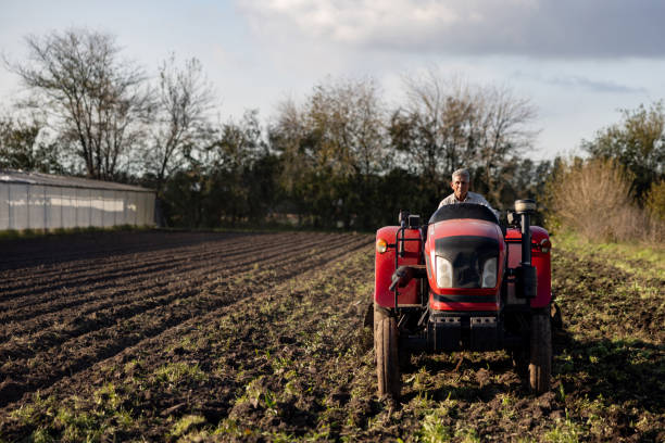 istock Farmer plowing an agricultural field using a tractor 2161558478