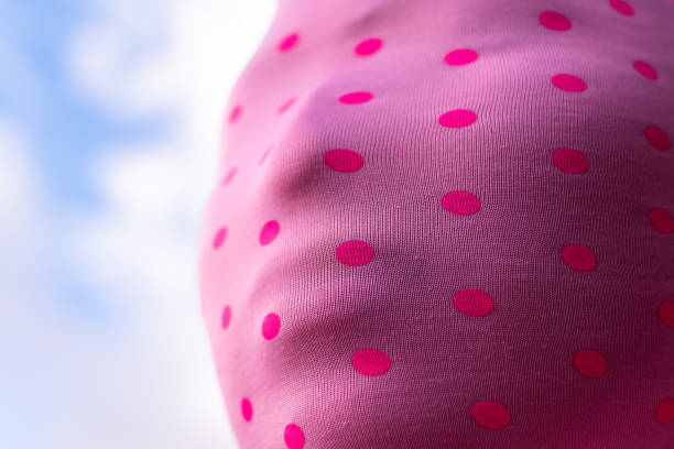 Close up of woman wearing pink mask with many red spots