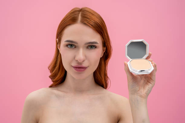 istock Ginger woman with bare shoulders with cream powder in hands 2161572573