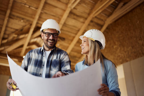 istock Happy couple reading housing plans at construction site. 2161572860