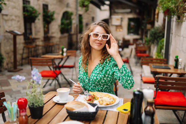 istock Young woman using mobile phone while walks with a bicycle and looks around at beautiful architecture. 2161574042