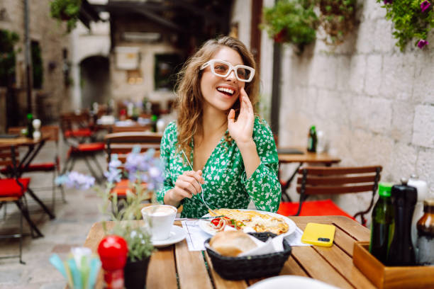 istock Young woman using mobile phone while walks with a bicycle and looks around at beautiful architecture. 2161574046