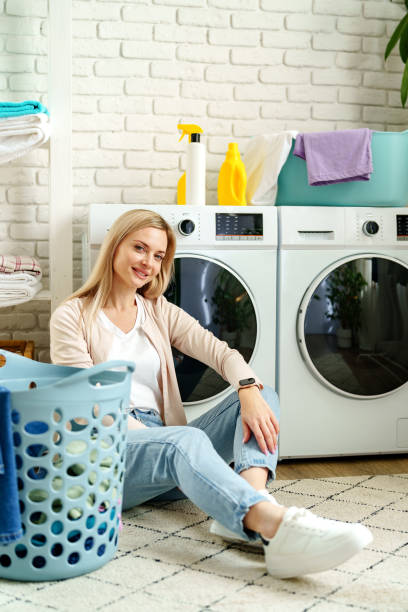 istock Woman Leaning On Washing Machine In Laundry Room 2161574294