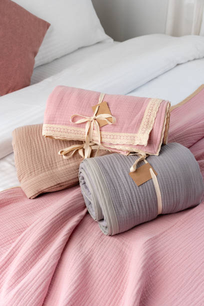 istock Rolled Up Soft Pink and Grey Muslin Blankets on Bed 2161575523