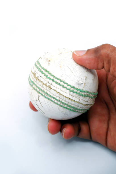 Man holding a white color cricket ball close-up shot on white background