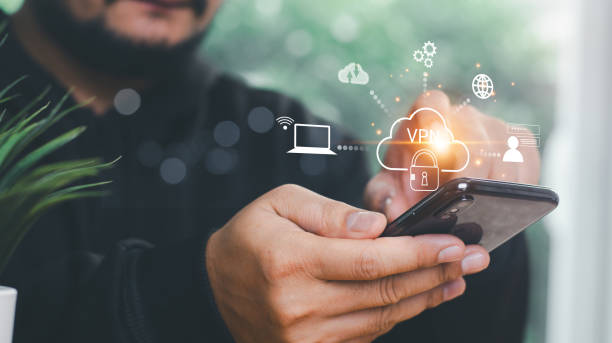 istock VPN Virtual private network concept. Man hand using Smartphone with vpn icon on VR screen. virtual private network channels a secure data connection between your local machine and another VPN server. 2161576628