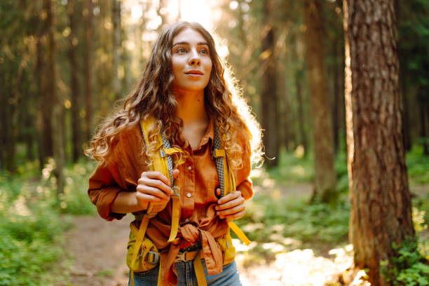 istock Woman tourist yellow backpack hiking in spring forest 2161576633