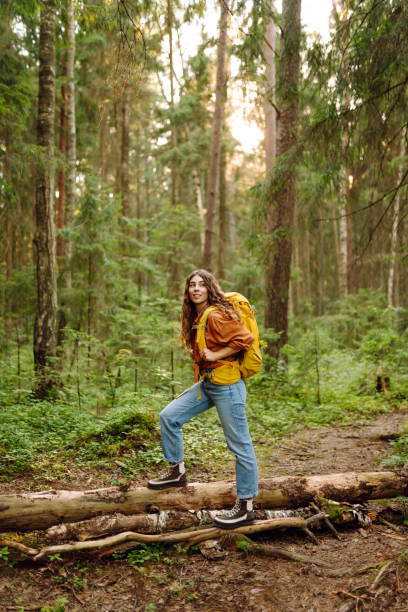 istock Woman tourist yellow backpack hiking in spring forest 2161576637