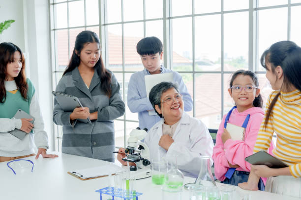 istock Science teacher Introducing female students in the classroom Let the microscope be used during elementary school science lessons. Groups of students try to look at microorganisms through microscope. 2161577803