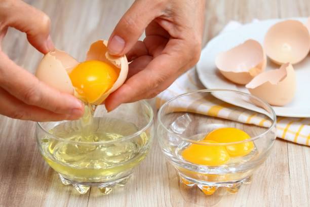 istock Woman hands breaking an egg to separate  egg- white and  yolk. 2161585769