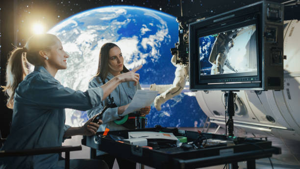 istock Filmmakers Direct a Female Astronaut Scene Using Virtual Production. Actor on Harness Simulates Spacewalk Against Digital Earth Backdrop. Behind-the-scenes of Ad Shoot. 2161588946