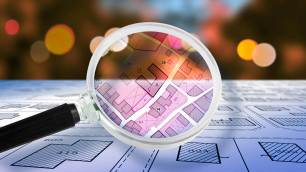 istock FIND VACANT LAND FOR BUILDING ACTIVITY AND HOME DEVELOPMENT - Concept with magnifying glass on cadastral map to find the plots of land - Building roject concept 2161589634