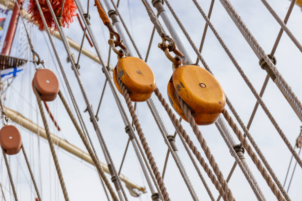 istock Sailing ship lines, pulleys and securing equipment tied down for the day. Deck and ropes, rigging on a wooden tall ship sail yacht. Close up view 2161592495